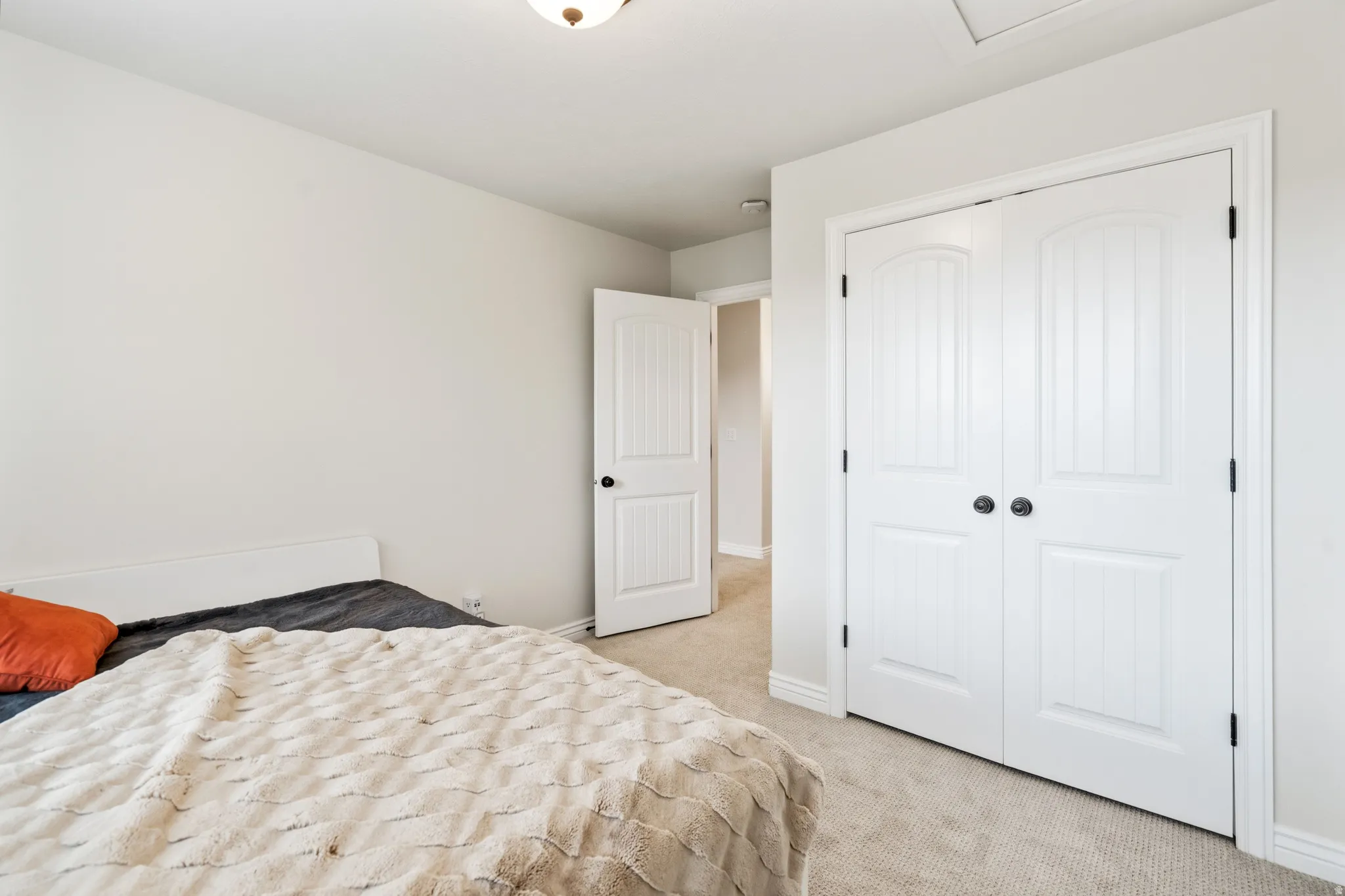 White paneled bifold closet doors, light neutral wall paint, and recessed lighting