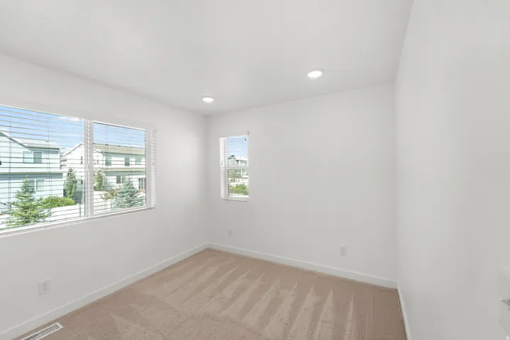 Recessed lighting, light-colored walls, and two windows with blinds