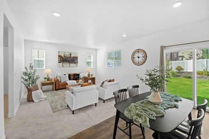 Recessed lighting, wood-finish flooring, sliding glass door, white walls, and a green yard
