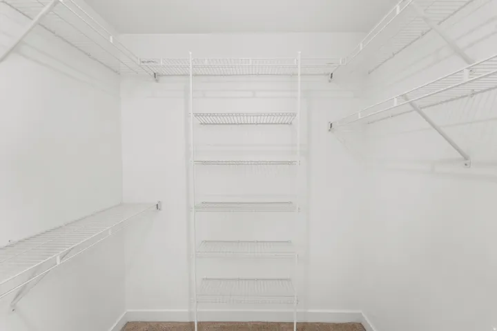White wire shelving system with multiple shelves and hanging rods