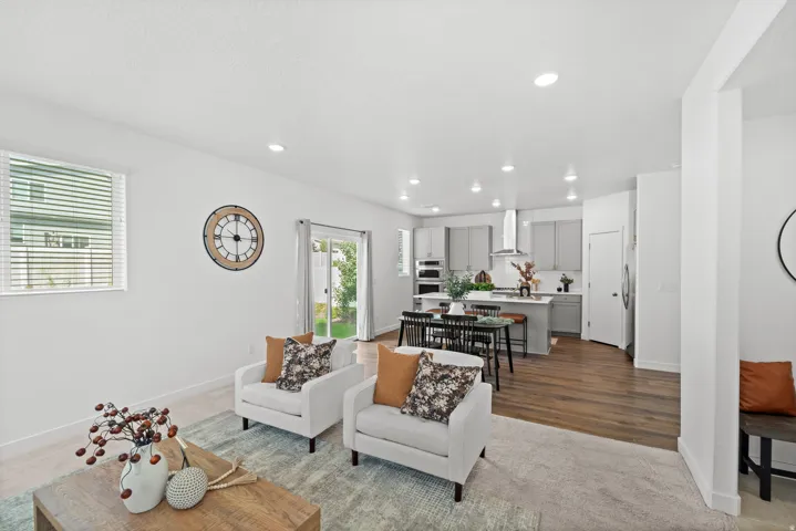 Open-concept living space featuring wood-finish flooring, recessed lighting, and a sliding glass door