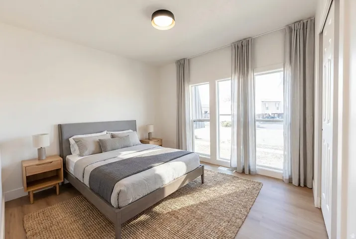 Recessed lighting, light wood-finish flooring, and multiple windows with drapery