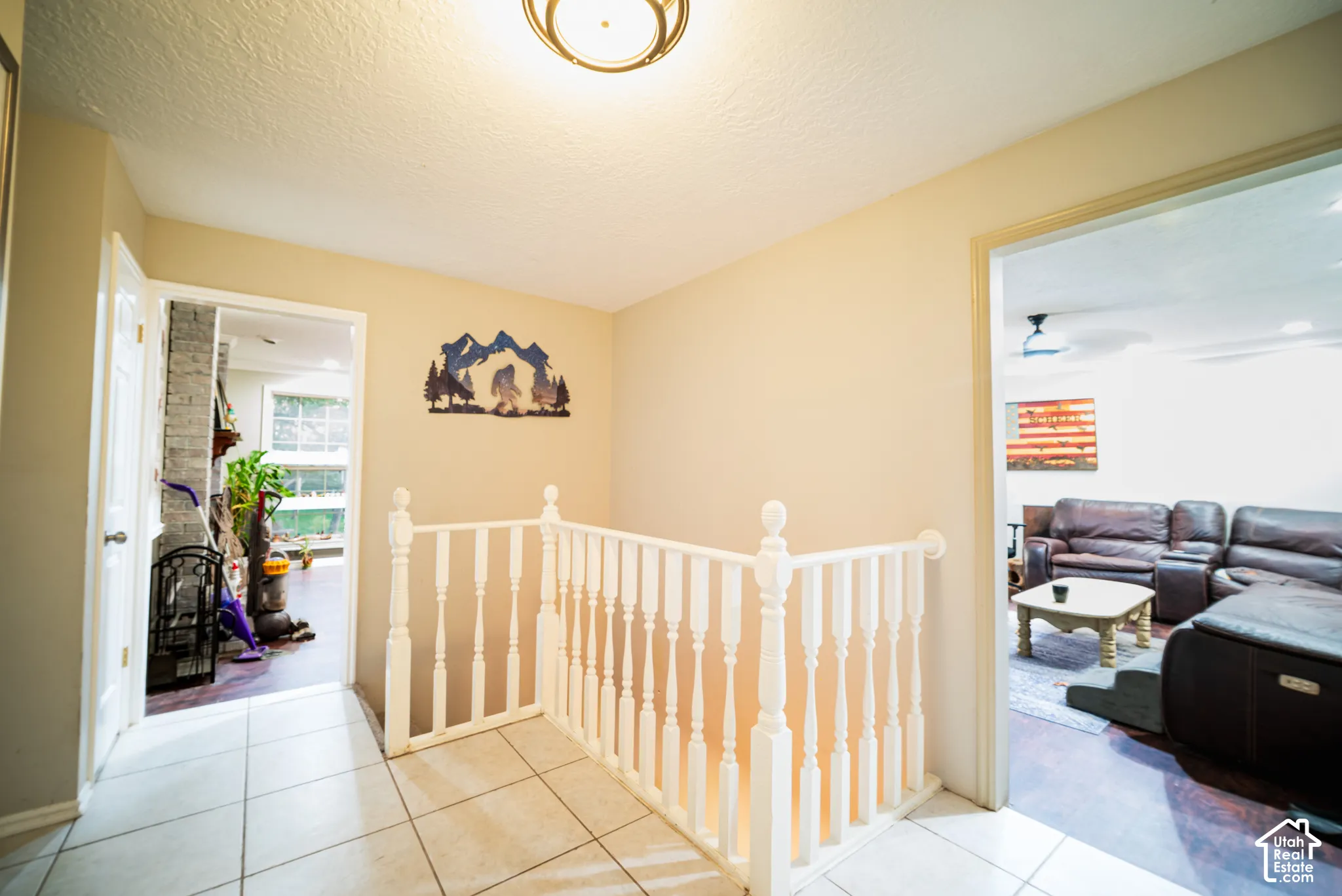 White spindle railing, tiled flooring, and recessed ceiling light fixture