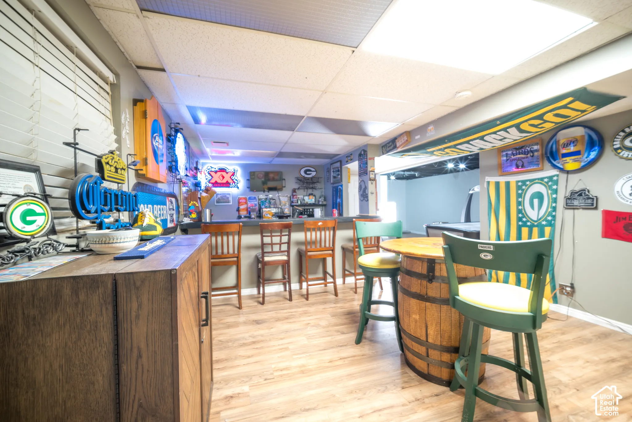 Wood-finish flooring, built-in bar, recessed lighting, and a window with blinds