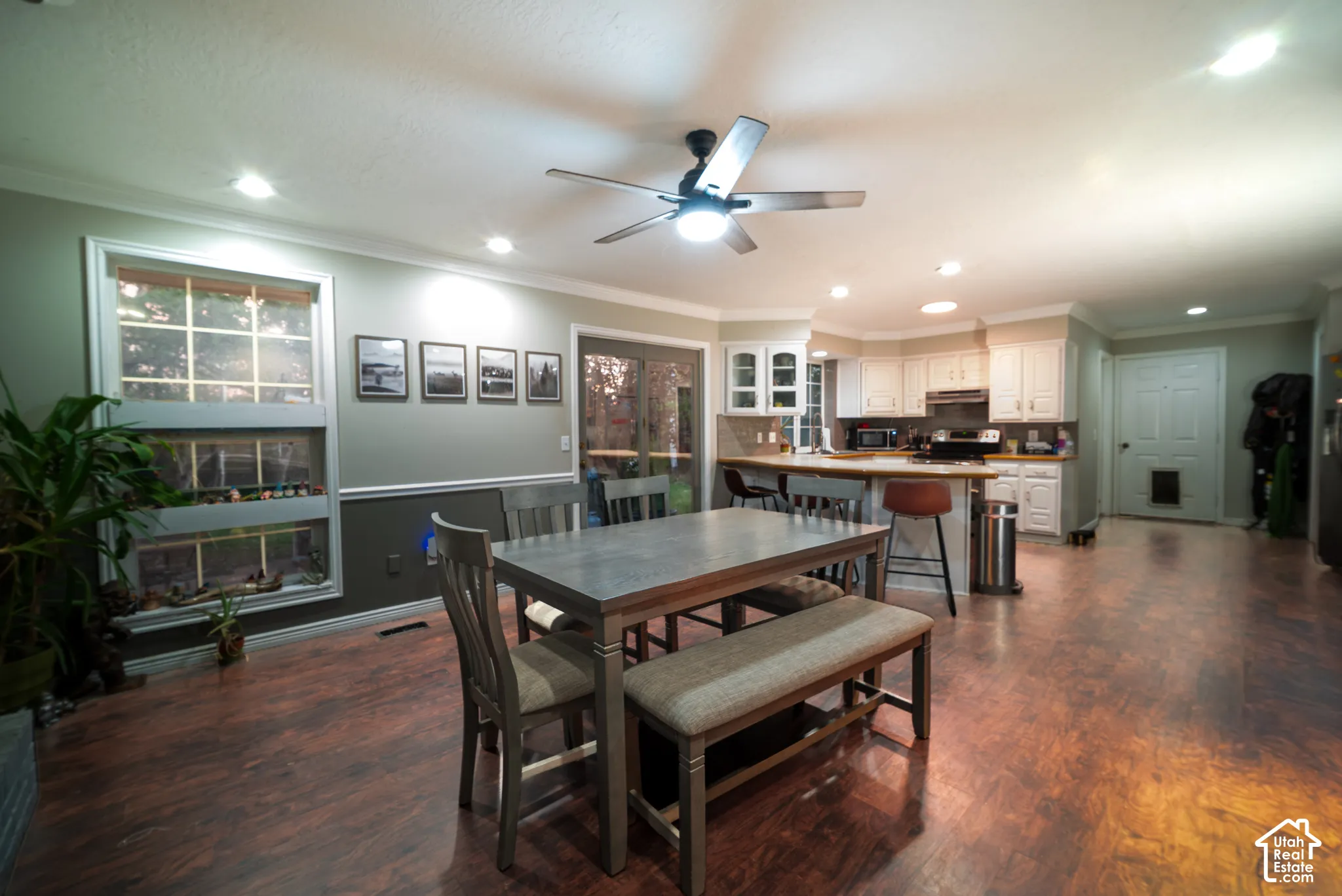 Expansive open-concept room featuring wood-finish flooring, recessed lighting, and a contemporary ceiling fan