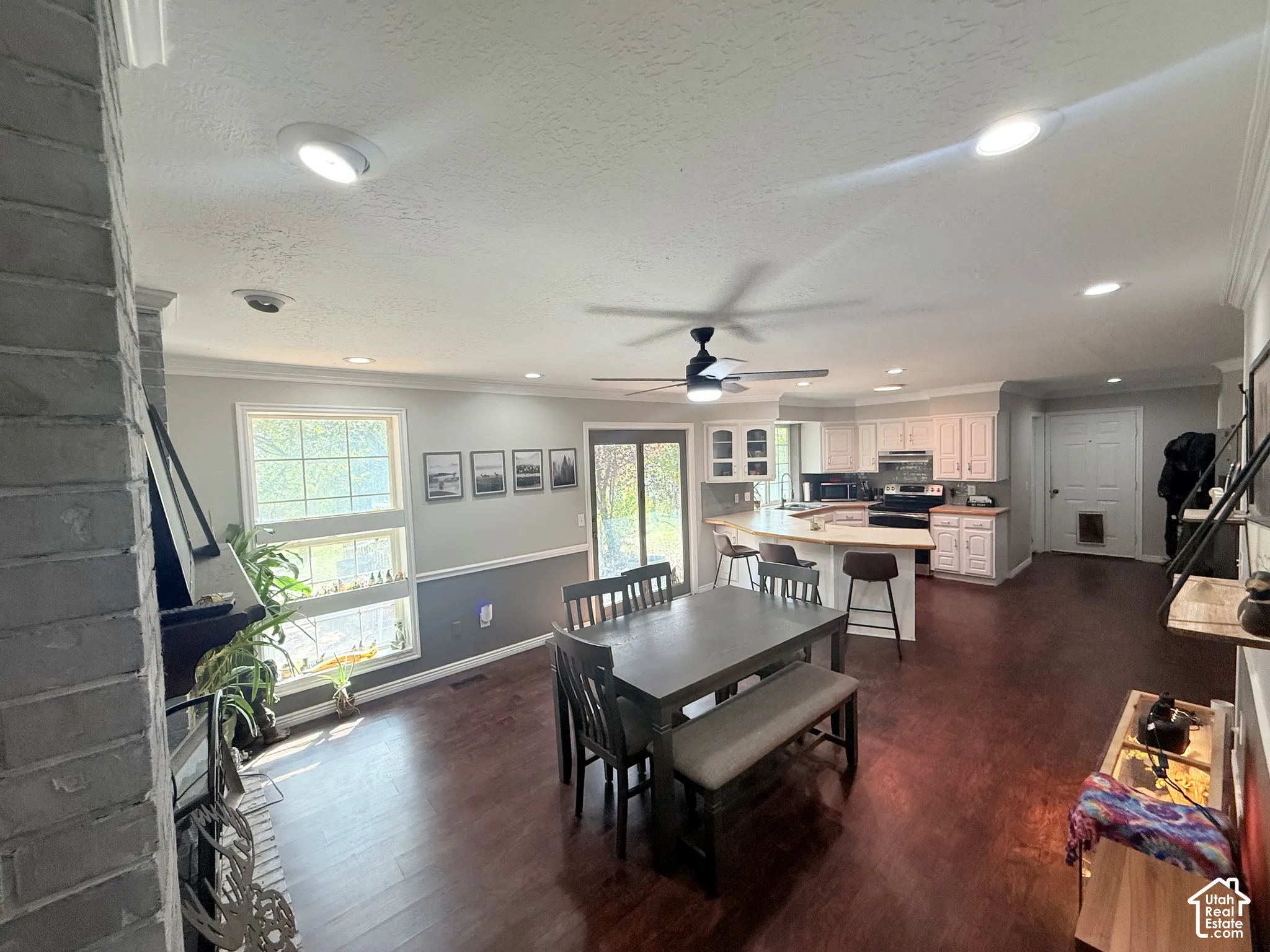 Open-concept living space with dark wood-finish flooring, recessed lighting, and a ceiling fan