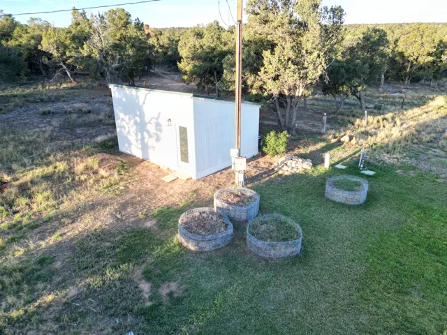 White corrugated metal outbuilding with a single pane door