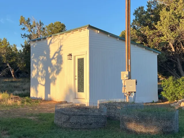 White vertical siding exterior with a green-trimmed roof