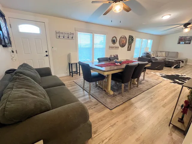 Open-concept living area with wood-finish flooring, recessed lighting, and multiple ceiling fans
