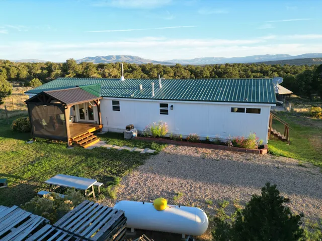White exterior with a green metal roof