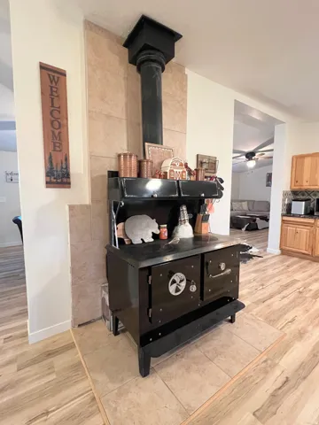 Freestanding wood-burning stove with a black finish, set on a tiled hearth