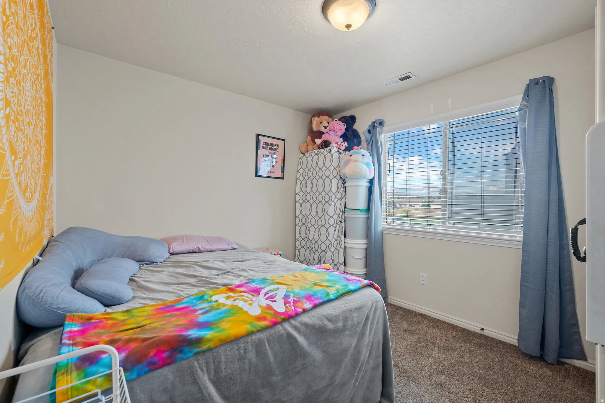 Carpeted flooring, neutral wall color, and a window with blinds