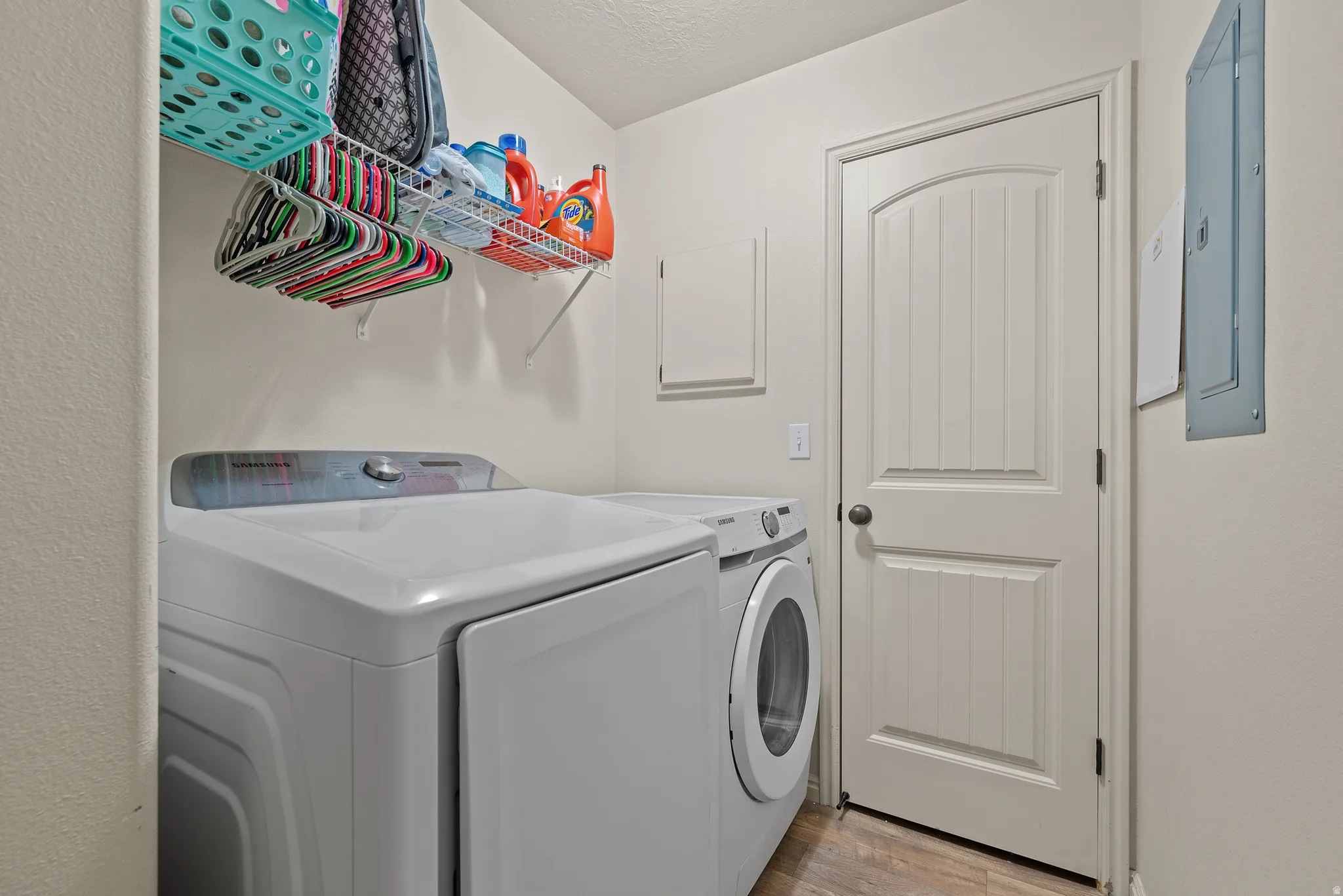 Utility space featuring a wood-finish floor and a white paneled door