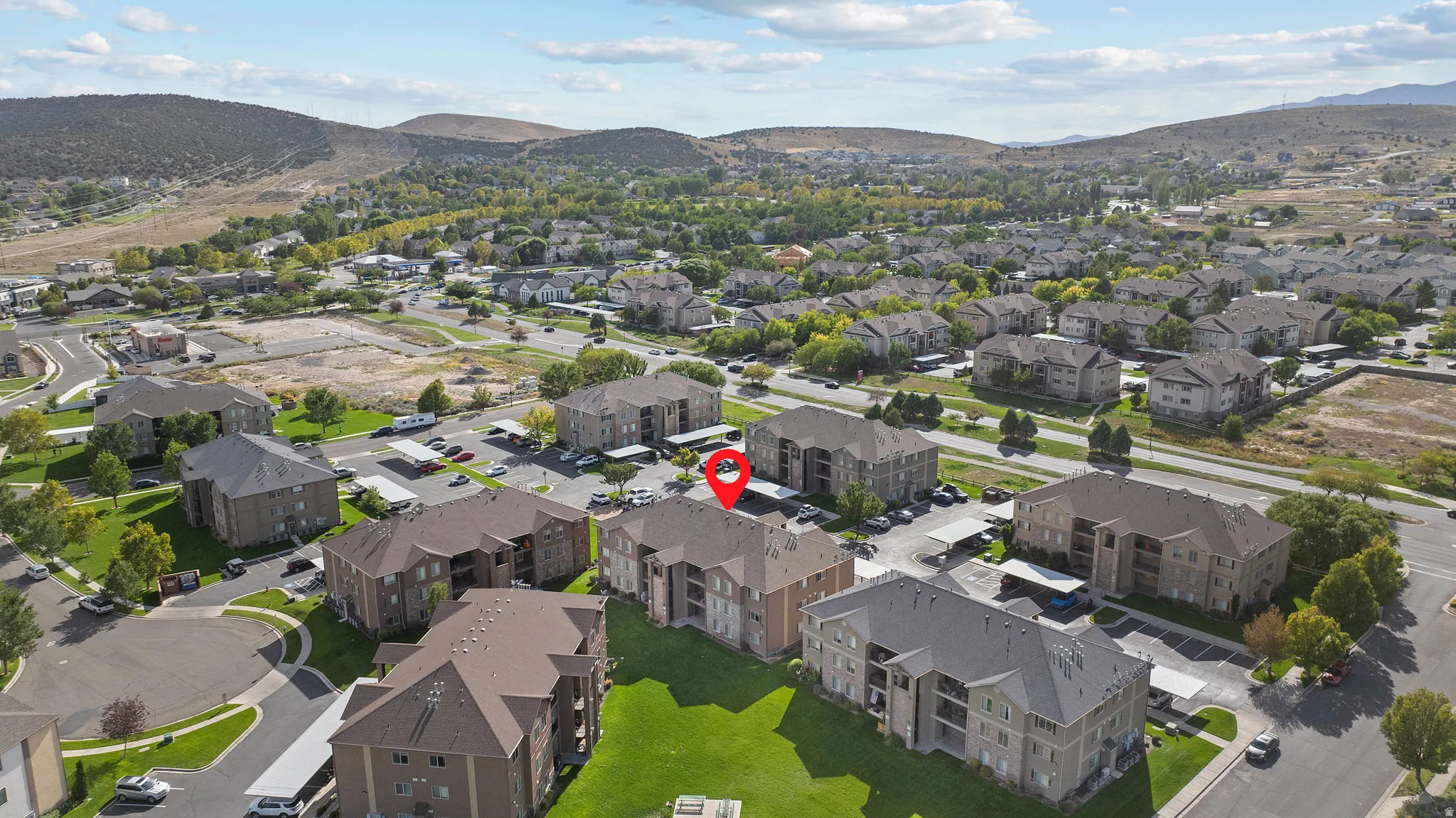 Expansive community with multi-story residential buildings, ample surface parking, and covered parking structures