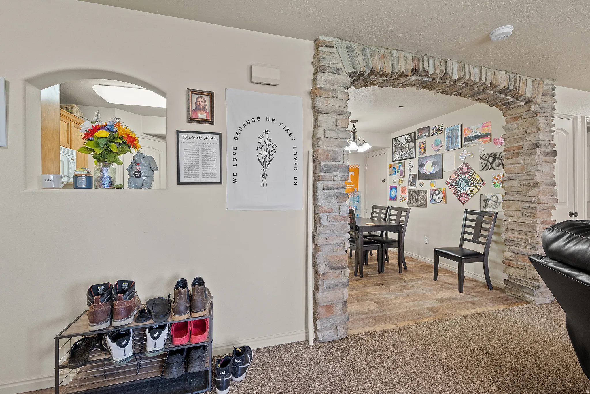 Stone archway entry to a dining area with wood-finish flooring