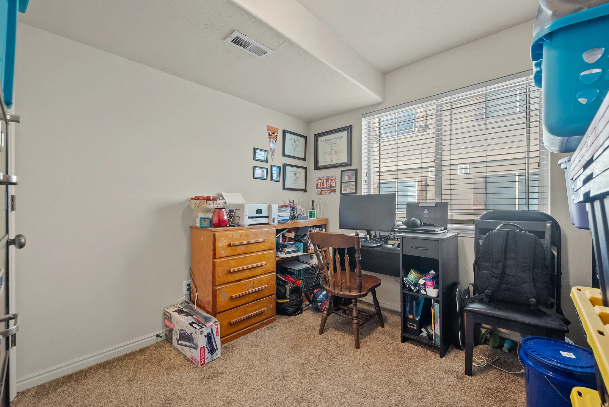 Carpeted flooring, white walls, and a window with horizontal blinds