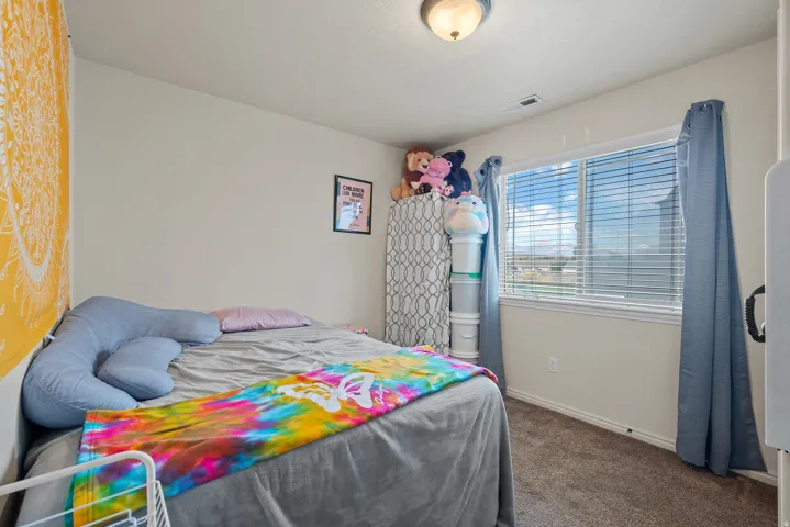 Carpeted flooring, neutral wall color, and a window with blinds
