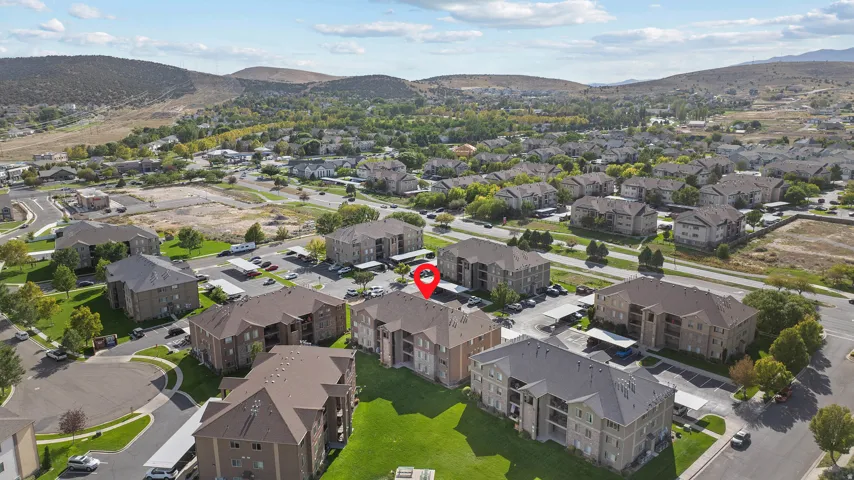 Expansive community with multi-story residential buildings, ample surface parking, and covered parking structures