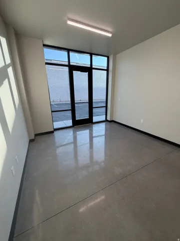 Polished concrete flooring, full-height glass entry, and recessed lighting
