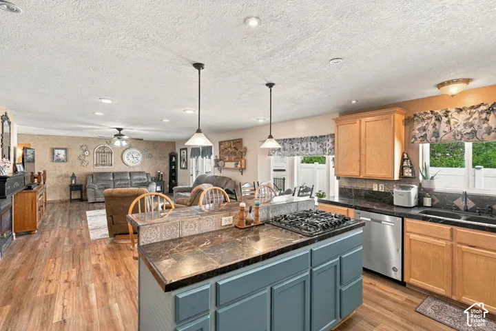 Kitchen island with integrated gas cooktop, wood-finish flooring, recessed lighting, and light wood cabinetry