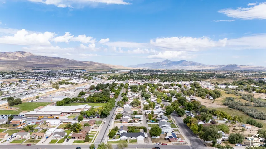 Expansive residential neighborhood with mature trees, established roads, and distant mountain ranges