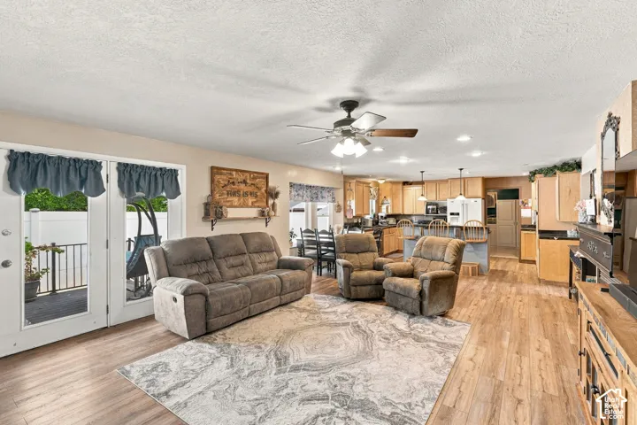 Expansive living area featuring wood-finish flooring, recessed lighting, and a ceiling fan