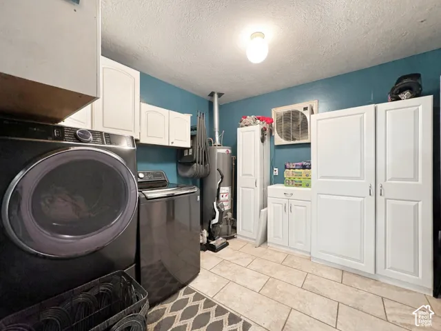 Tile flooring, white cabinetry, overhead lighting, and wall-mounted storage options