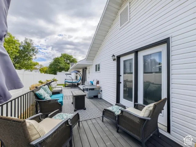 Expansive deck with composite decking, white vinyl fencing, and direct access through double glass doors