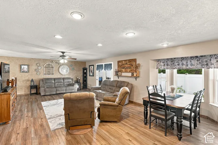 Recessed lighting throughout, wood-finish flooring, ceiling fan, and a dining area with a bay window
