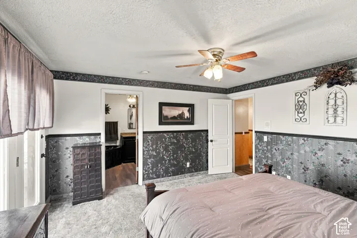 Ceiling fan with integrated lighting, wall-to-wall carpeting, and a white paneled door