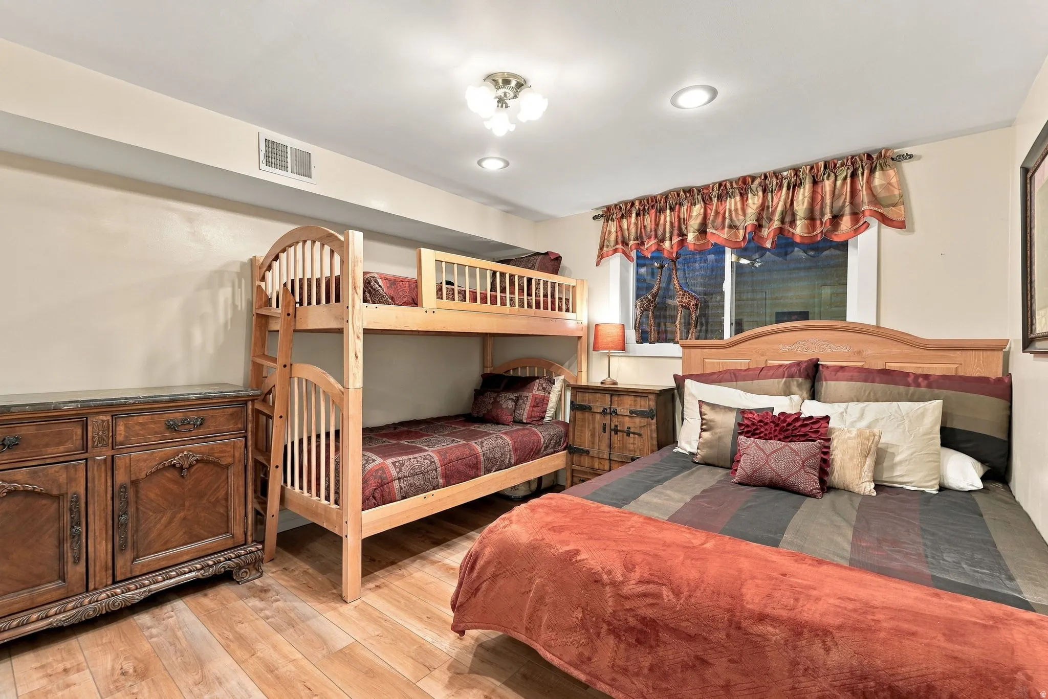 Recessed ceiling lighting complements the overhead light fixture in this room featuring wood-finish flooring
