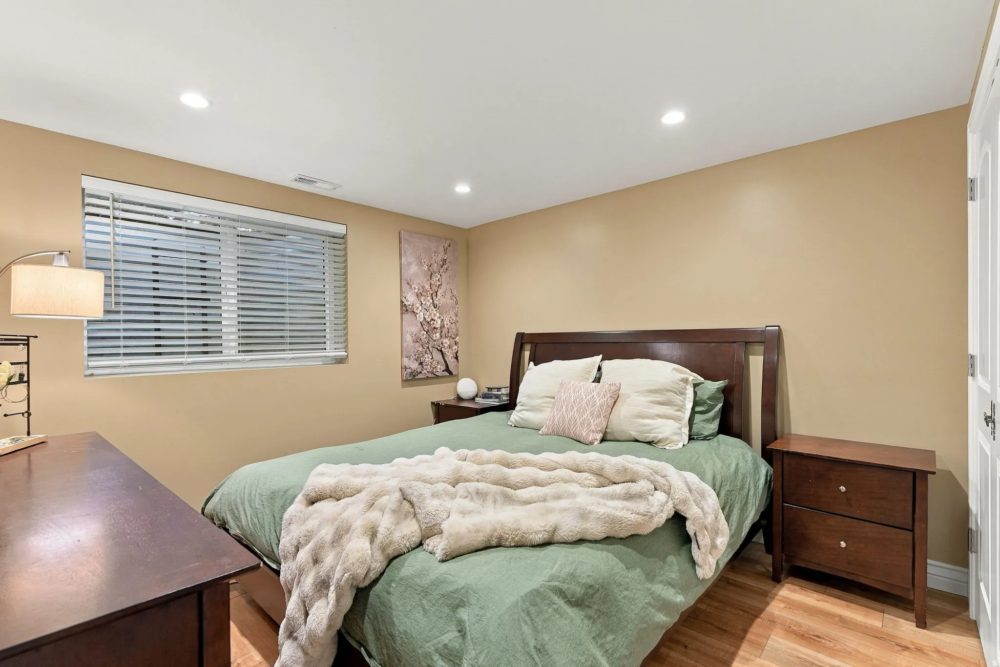 Recessed lighting, wood-finish flooring, and a window with blinds