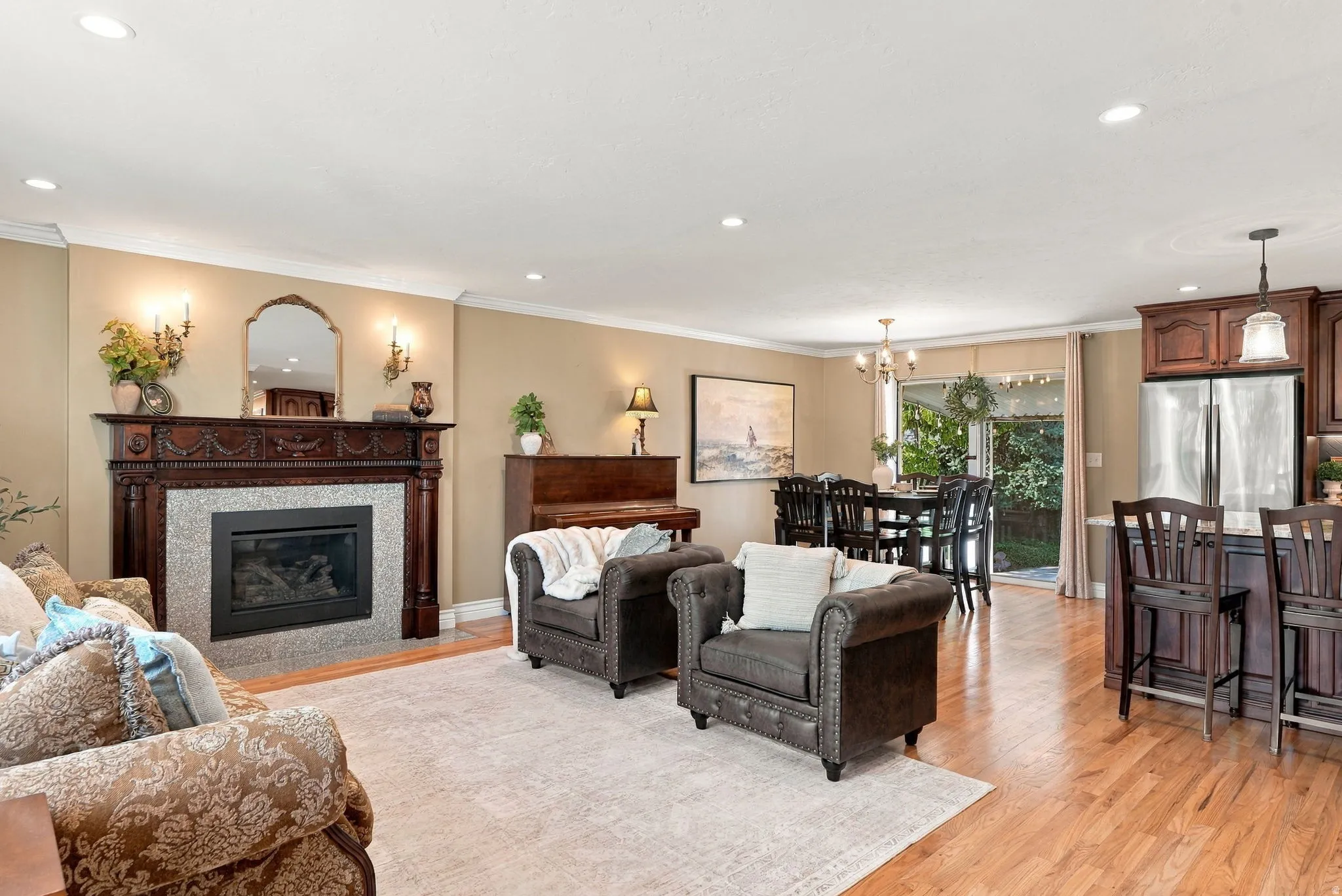 Hardwood flooring throughout, recessed lighting, and a detailed fireplace with a stone surround