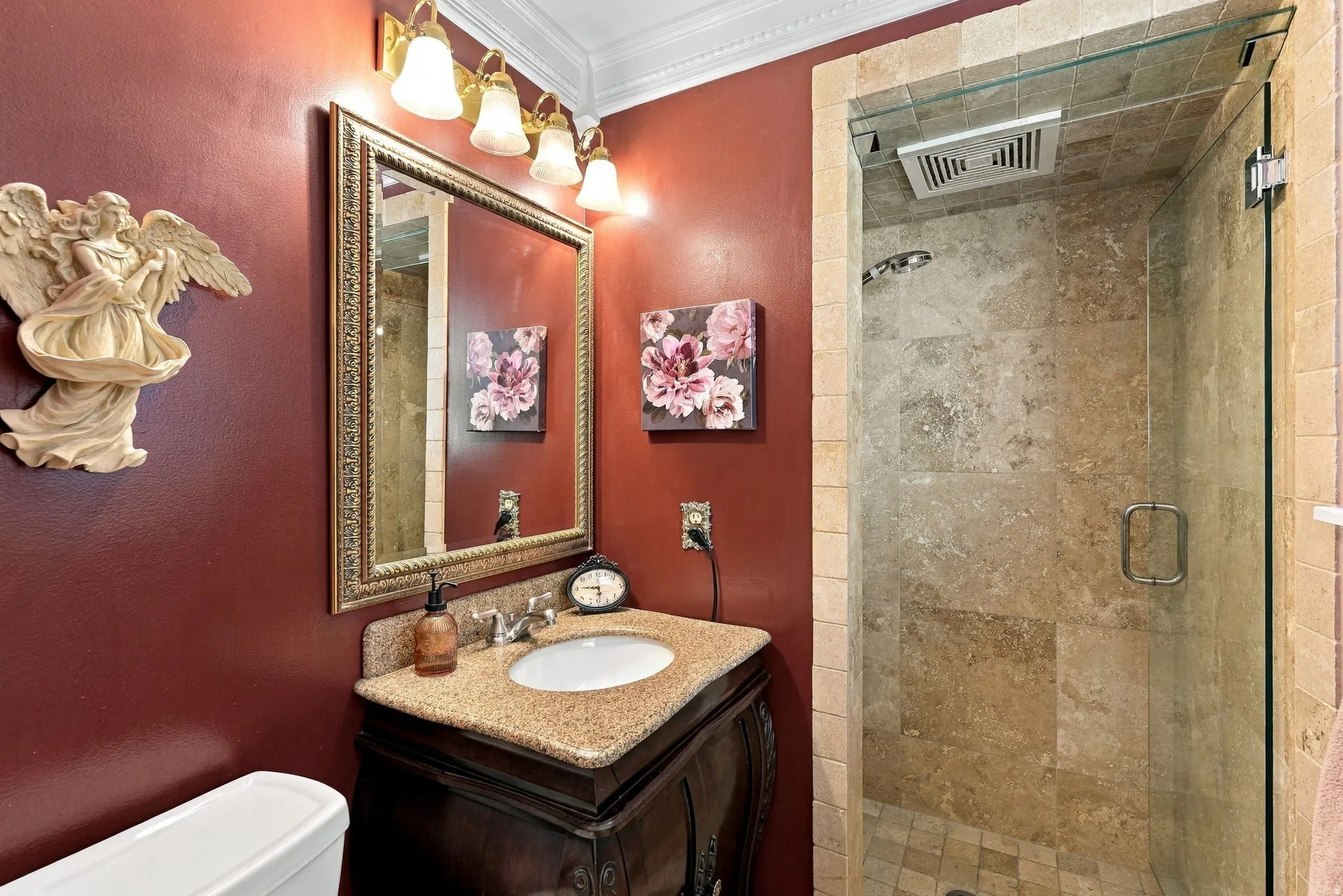 Built-in vanity with a granite countertop, undermount sink, and ornate mirror