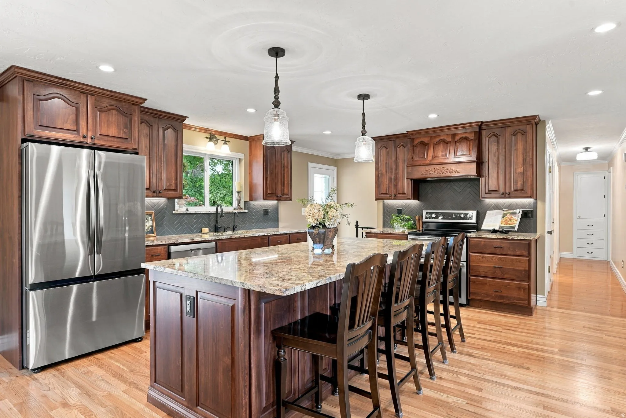 Kitchen featuring wood-finish cabinetry, stainless steel appliances, a center island with a stone countertop, and wood-finish flooring