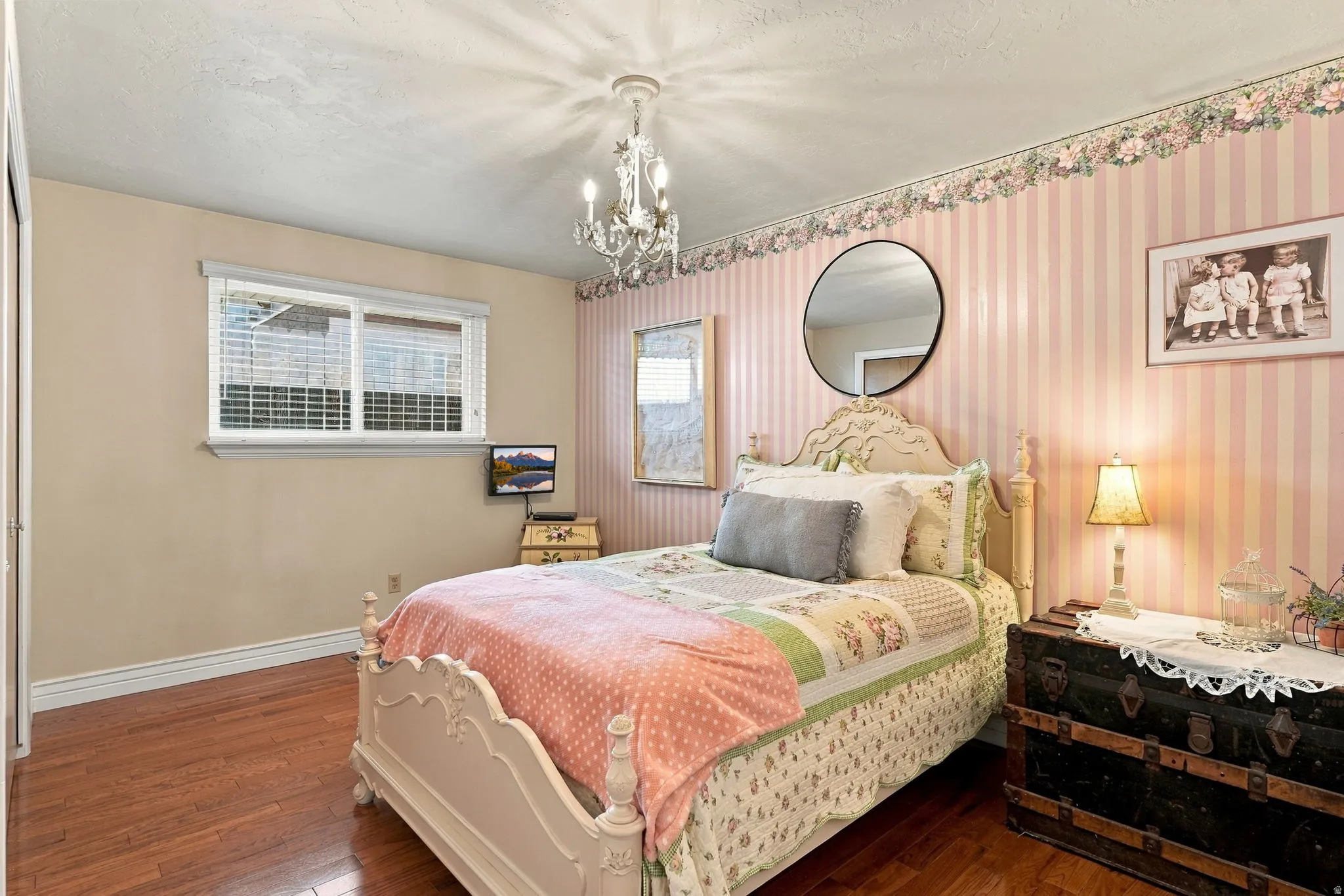 Hardwood-style flooring, a window with horizontal blinds, and a built-in closet with bi-fold doors
