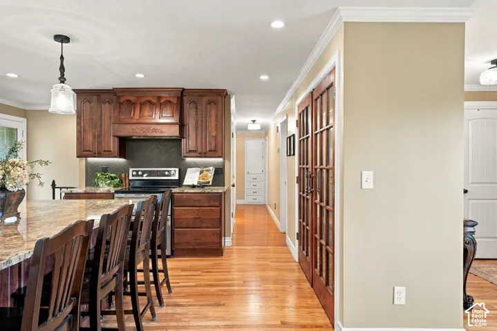 Kitchen featuring rich wood cabinetry, granite countertops, and a herringbone tile backsplash