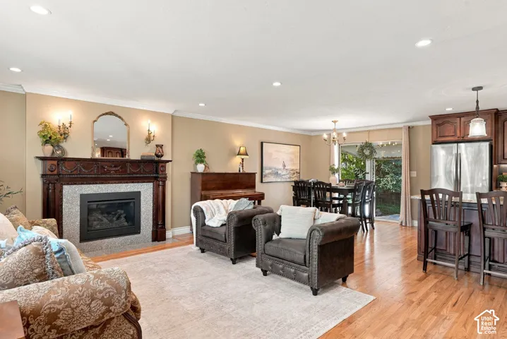 Hardwood flooring throughout, recessed lighting, and a detailed fireplace with a stone surround