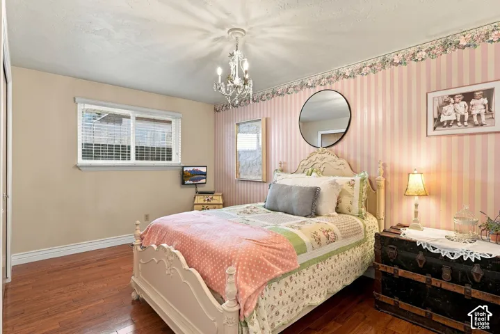 Hardwood-style flooring, a window with horizontal blinds, and a built-in closet with bi-fold doors