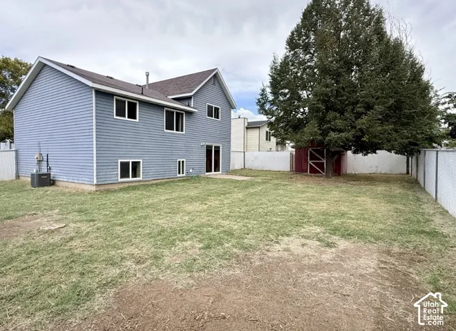 Two-story residence with light blue siding, a dark roof, and multiple windows