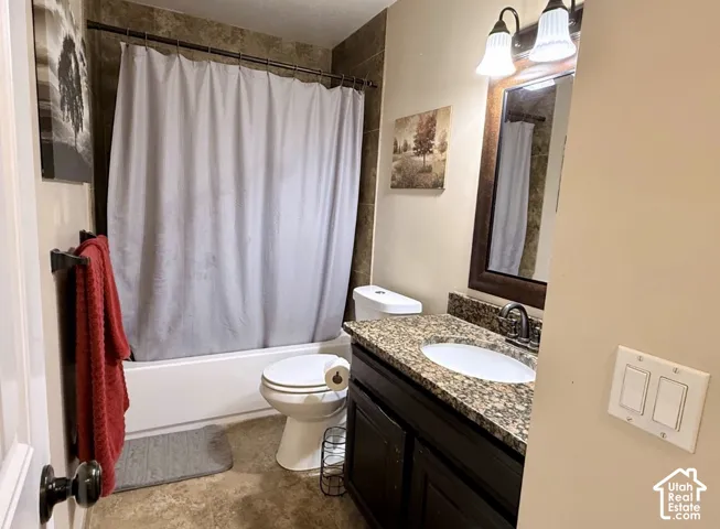 Full bathroom featuring a dark wood finish vanity with a granite-look countertop, integrated sink, and brushed nickel faucet