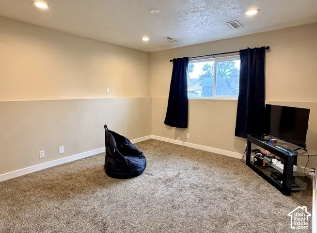 Recessed lighting, neutral wall tones, white trim, and carpeted flooring