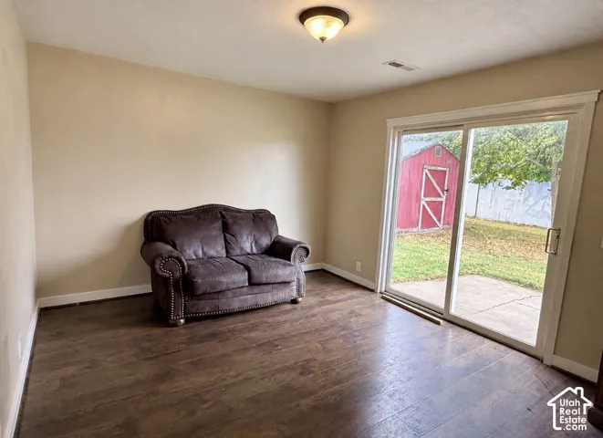 Wood-finish flooring, sliding glass door, patio area, and a detached storage shed