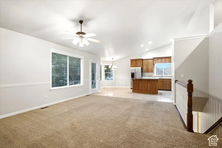 Open concept interior with vaulted ceilings, recessed lighting, and a ceiling fan