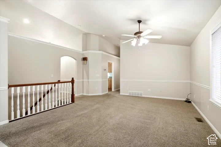 Vaulted ceilings, recessed lighting, and a ceiling fan create a bright atmosphere