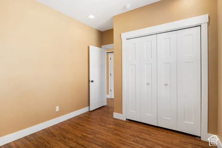 Wood-finish flooring, recessed lighting, white interior doors, and white bi-fold closet doors