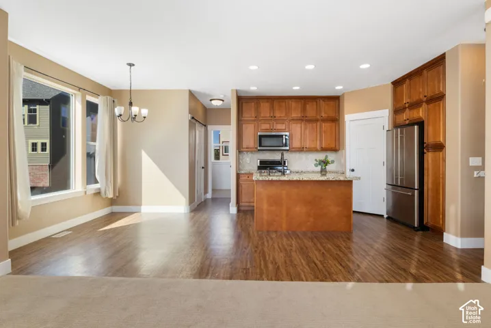 Open-concept living space featuring wood-finish flooring, recessed lighting, and large windows