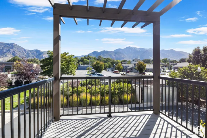 Deck with a pergola, dark metal railings, and a composite deck surface