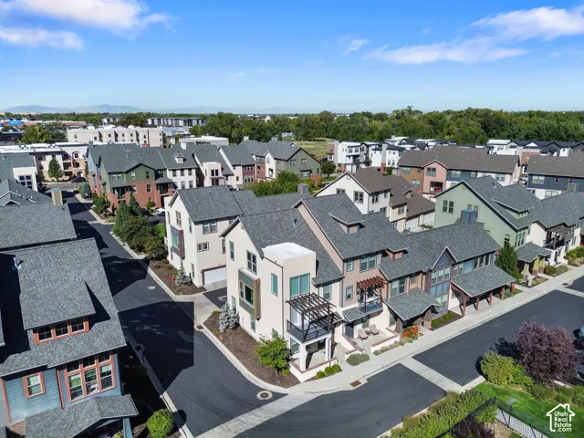 Mixed-material facades, varied rooflines, private balconies, attached garages, and mature landscaping