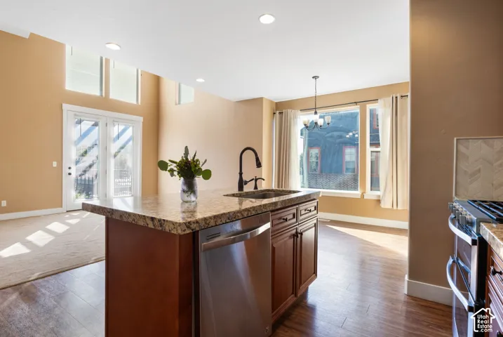 Kitchen island with a granite countertop, undermount sink, and stainless steel dishwasher